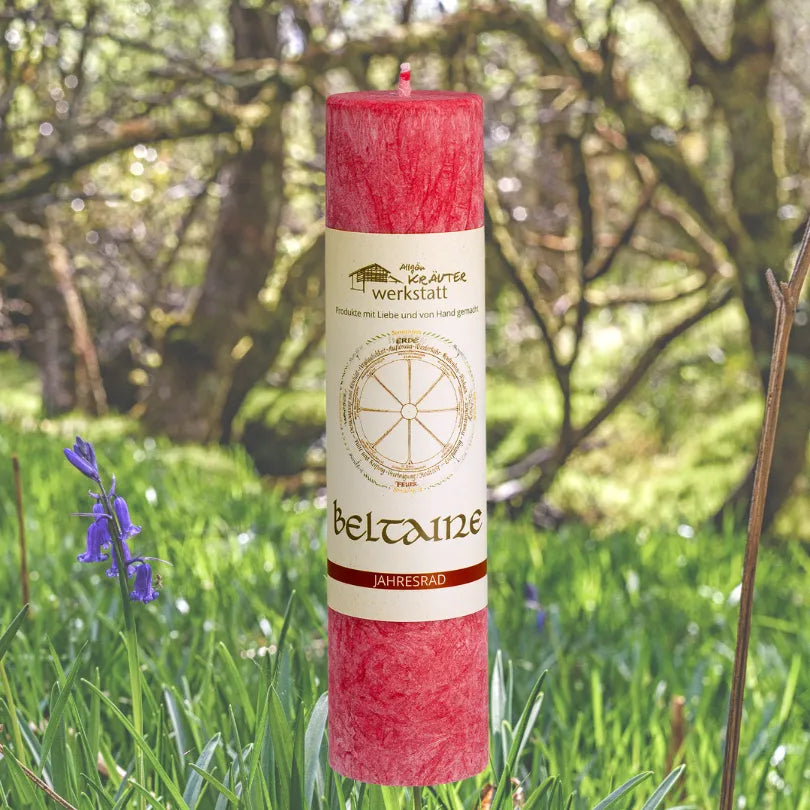 Rote Kräuterkerze "Beltaine" in blühender Natur, feiert das Erwachen der Natur & weckt innere Urkraft.