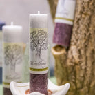 Weiß-violette Kräuterkerze "Wandlung" auf Kerzenteller, hilft Altes loszulassen & neue Wege zu gehen.