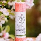 Rosa Allgäuer Heilkräuterkerze "Harmonie und Liebe" mit Weißdorn und Mariengras in natürlicher Umgebung.