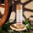 Braune Kräuterkerze "Herbst-Tag-u.-Nachtgleiche" neben Holzrad, ideal für Herbstrituale & Traumarbeit.