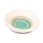 Handgetöpferter Kerzenteller aus dem Allgäu mit türkis-farbener Glasur und Lochprägung, Seitenansicht.