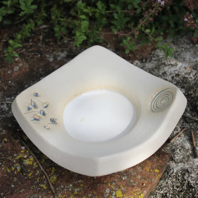 Weißer leerer, handgetöpferter Kerzenteller mit blauen Blüten und Spiralverzierung, ein Unikat.