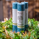 Drei türkise Kräuterkerzen "Verbundenheit" in einem grünen Kranz, symbolisieren Harmonie & tiefe Naturverbindung.