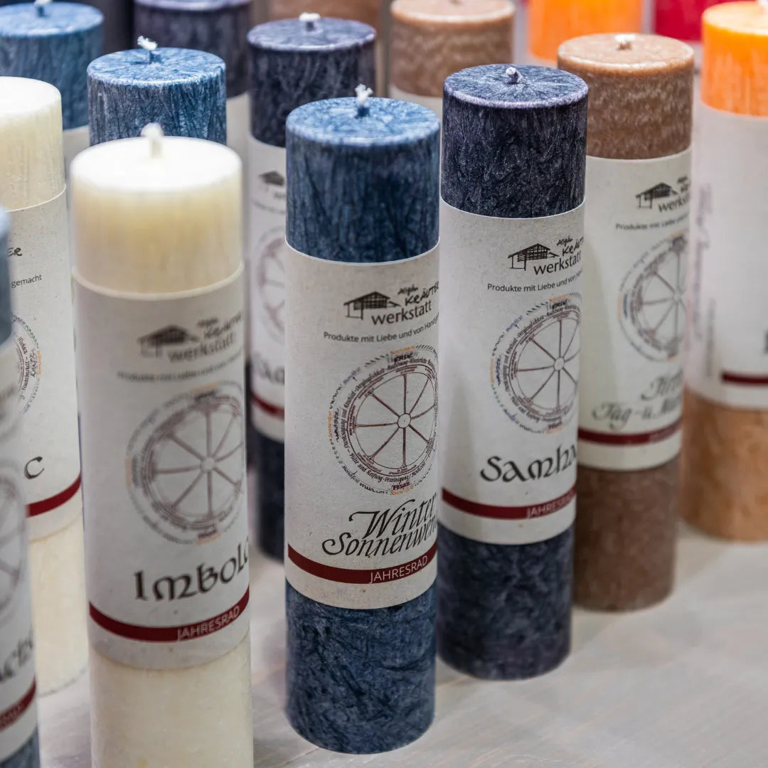 Vielfältige Allgäuer Heilkräuterkerzen "Jahresrad" in verschiedenen Farben, symbolisieren Zyklen & Naturverbundenheit.