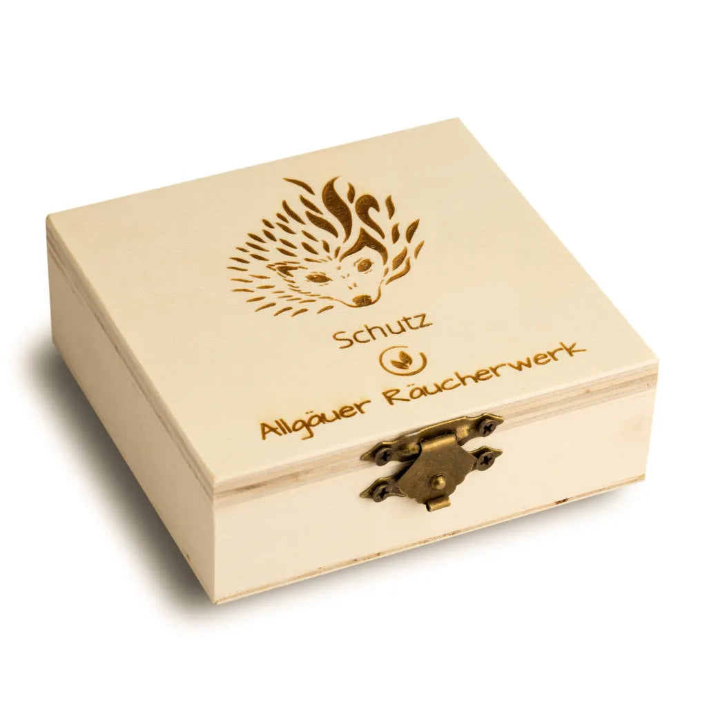 Geschlossene Holzbox "Allgäuer Räucherwerk Schutz" mit Igel-Motiv für Sicherheit und Geborgenheit.