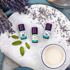 Baldini Bio ätherische Öle: Pfefferminze, Zitrone, Lavendel auf Marmorplatte mit Lavendelblüten.