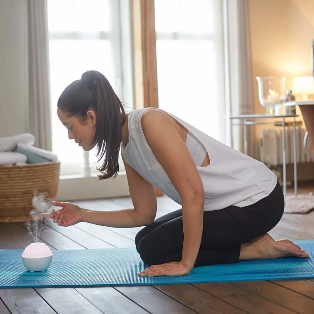 Frau auf Yogamatte mit TaoWell Mini Aroma Diffuser, Ultraschallvernebler für ätherische Öle.