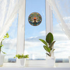 Runder Baum des Lebens Fensteraufkleber als Sonnenfänger auf hellem Fenster mit Pflanzen auf der Fensterbank, für harmonische Raumgestaltung.