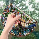 Hand zieht bunten Baum des Lebens Fensteraufkleber von Scheibe ab, demonstriert rückstandsloses Entfernen und Wiederverwendbarkeit.