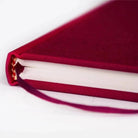 Nahaufnahme des bordeauxroten Semikolon Notizbuchs A5, zeigt Buchrücken und Leseband.