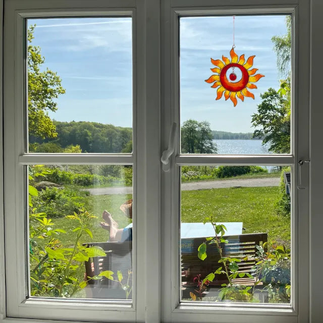 Sonnenfänger Sonne in Rot-Gelb am Fenster mit Seeblick, verschönert den Raum und hebt die Stimmung.
