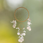 Großer Traumfänger mit Muschelplättchen und weißen Federn, handgefertigt für harmonische Raumenergie.