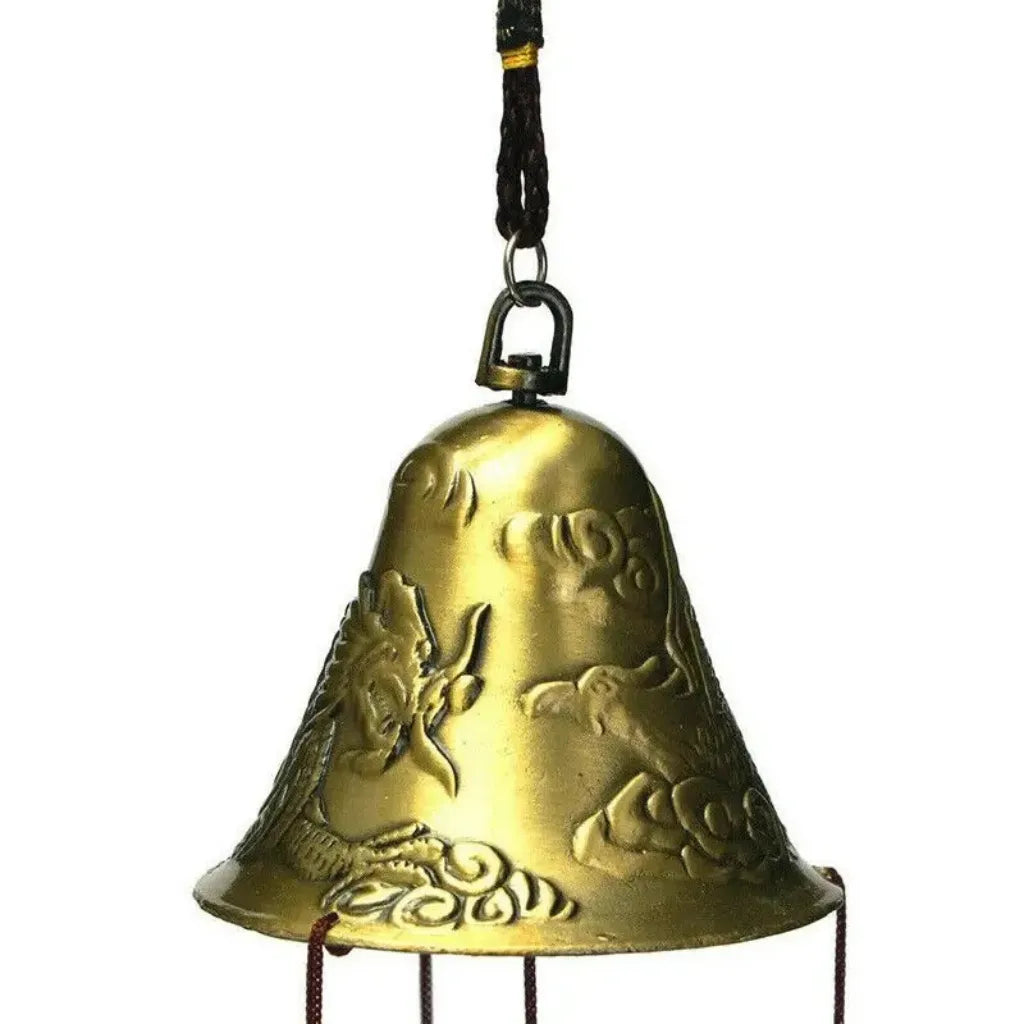 Nahaufnahme der goldfarbenen Glocke eines Windspiels mit Drachenmotiv.