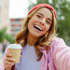 Lachende Frau mit Kaffeebecher, symbolisiert Freude, Freiheit und selbstbewusste Entscheidungen.