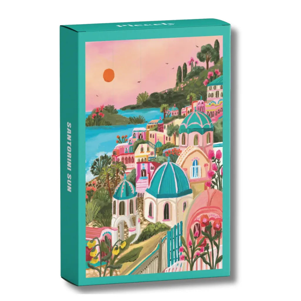 Frontansicht der Piecely Minipuzzle 99 Teile "Santorini Sun" Verpackung. Das Design zeigt die charmante Darstellung von Santorini mit seinen pastellfarbenen Häusern und dem blauen Meer.