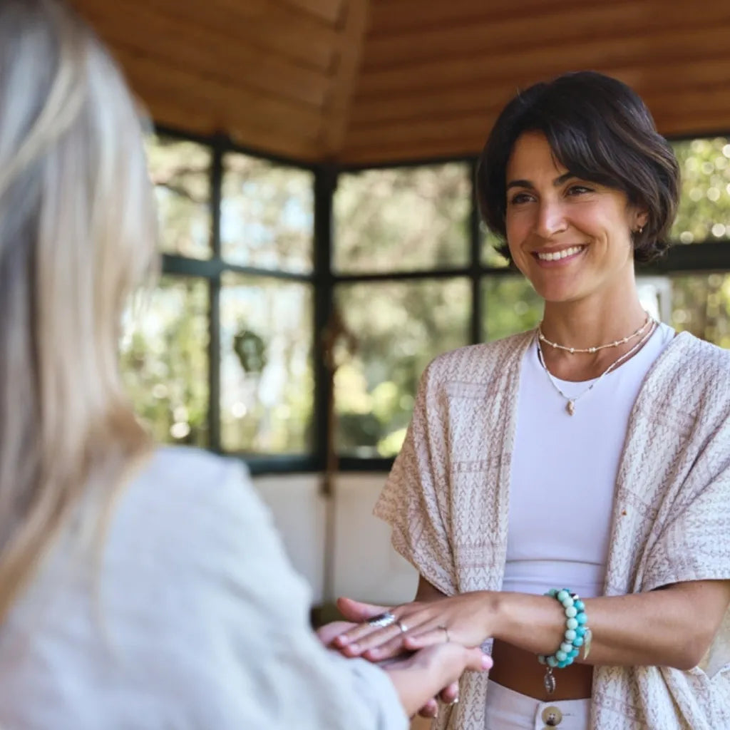 Frauen halten Hände, symbolisiert Unterstützung beim Loslassen & Stärken des Selbstwerts.