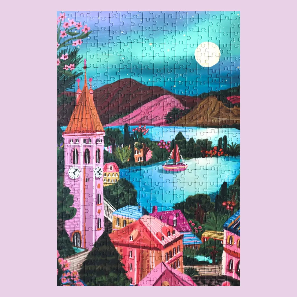 Das fertig gelegte Piecely Puzzle 500 Teile "Suisse Nights". Eine bezaubernde Illustration einer Schweizer Berg- und Seenlandschaft bei Nacht, mit rosa Uhrturm, bunten Häusern und einem vollen Mond.