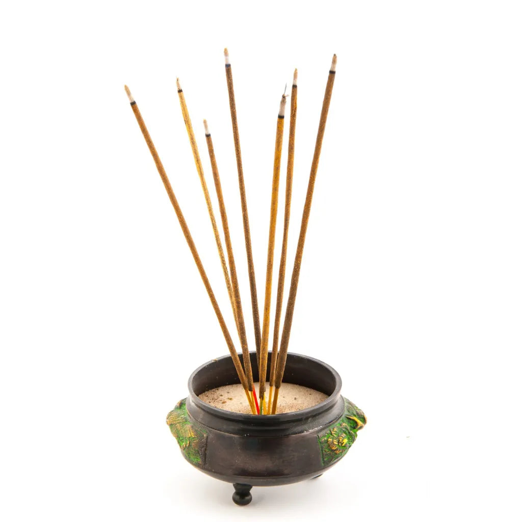 Mehrere Räucherstäbchen in einem verzierten Räuchergefäß mit Sand, bereit zum Anzünden.