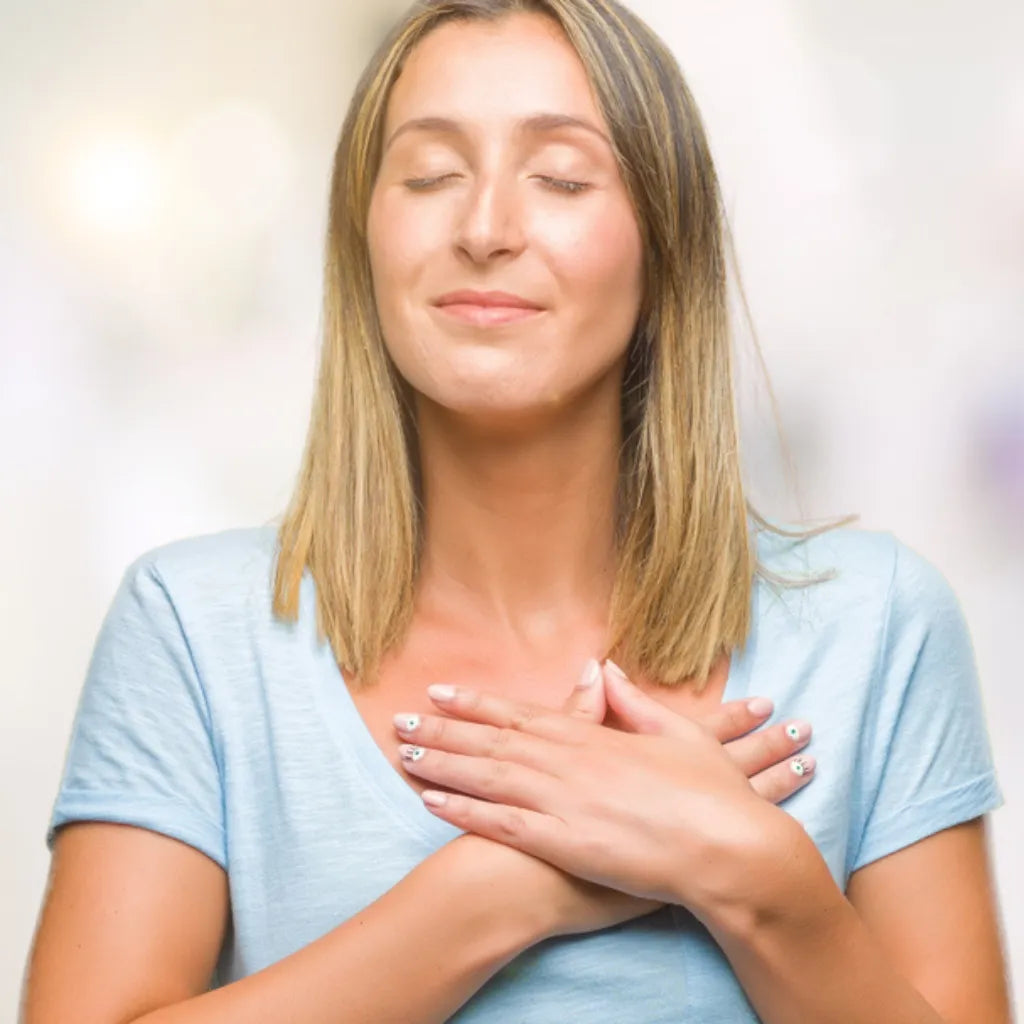 Frau mit Händen auf Brust, Augen geschlossen, symbolisiert Seelenkraft, innere Einkehr & Seelenplan.