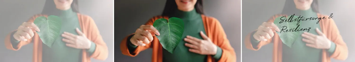 Frau hält herzförmiges grünes Blatt vor die Brust, symbolisiert Selbstfürsorge und Herzenswärme.