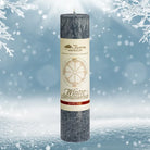 Dunkelgraue Kräuterkerze "Wintersonnenwende" vor Schneelandschaft, ideal für Rituale & Neuausrichtung. 