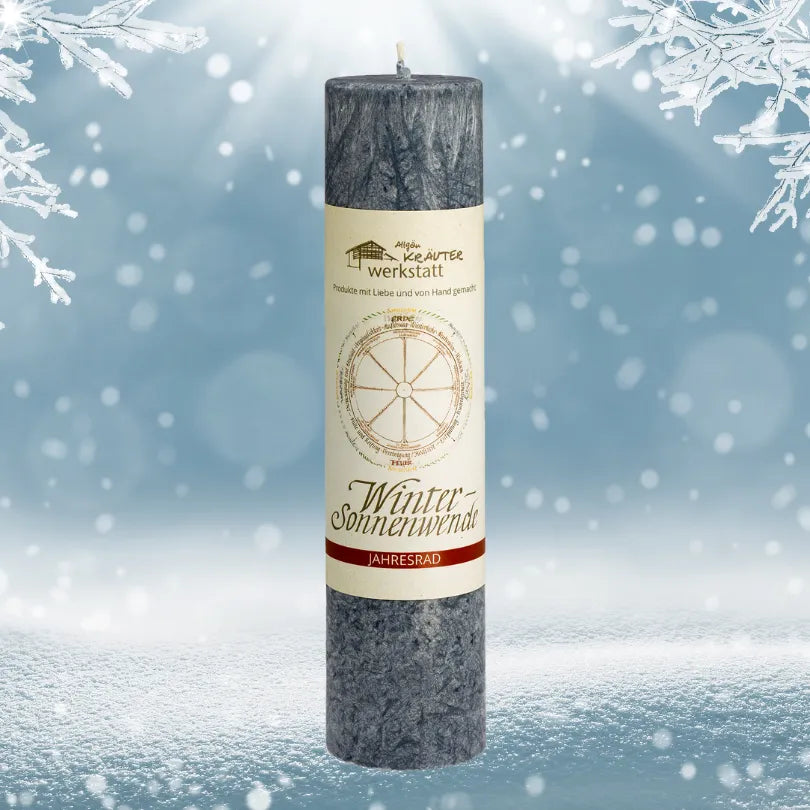 Dunkelgraue Kräuterkerze "Wintersonnenwende" vor Schneelandschaft, ideal für Rituale & Neuausrichtung. 