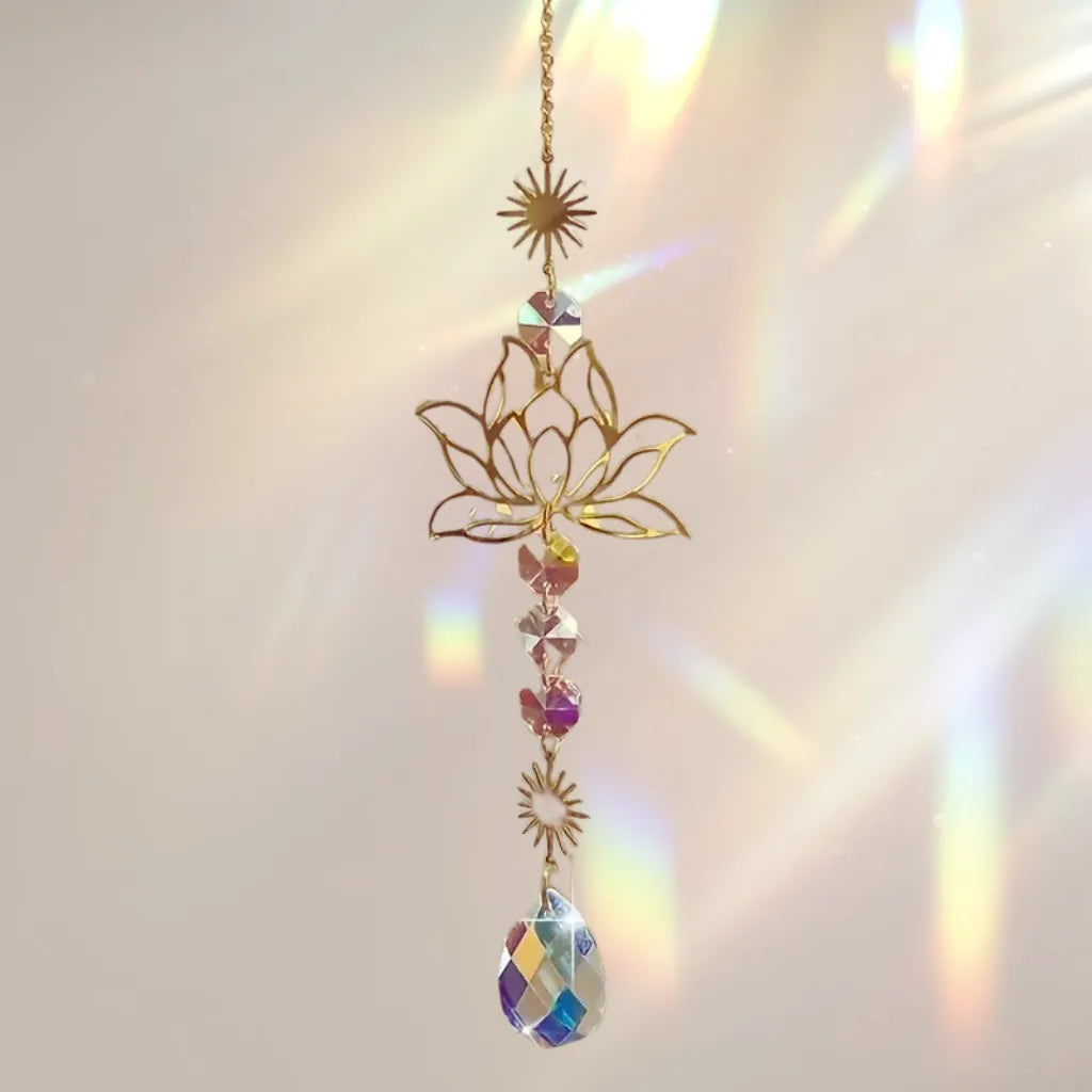 Elegante Sonnenfänger Kette mit goldenem Lotusmotiv erzeugt sanfte Regenbogenfarben und funkelnde Lichtspiele am Fenster.