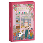 Piecely Minipuzzle 99 Teile "Cake & Love" Produktverpackung. Zeigt eine charmante Bäckerei-Fassade mit einem Hund, bunten Torten und festlicher Blumendekoration.